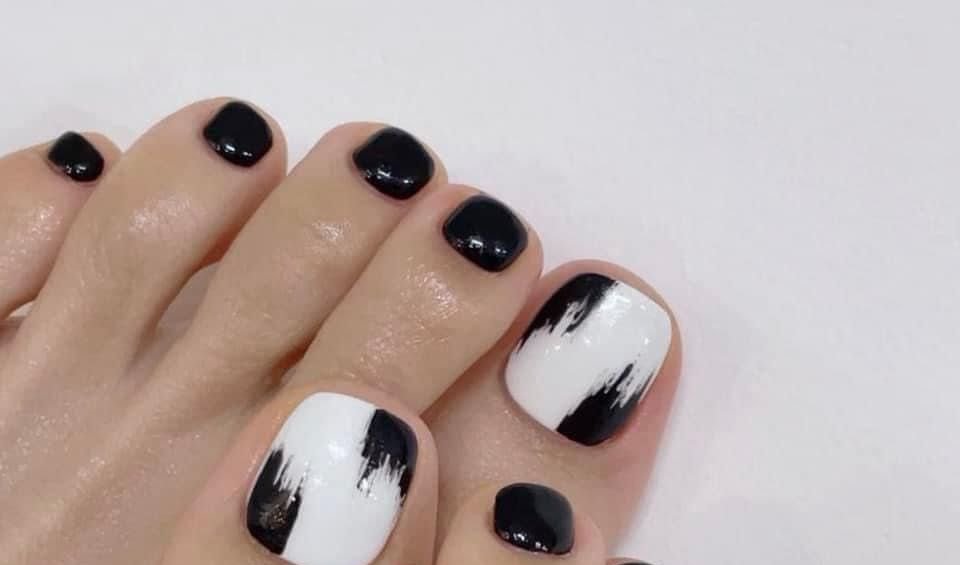 Pedicure w czerni i bieli z ręcznie malowanym wzorem